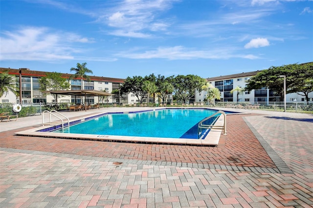 community pool featuring a patio area and fence