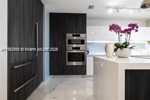 kitchen featuring double oven, modern cabinets, and light countertops