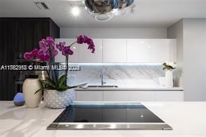 kitchen with a sink, visible vents, light countertops, and white cabinetry