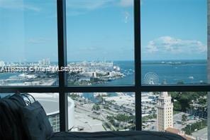 balcony featuring a water view and a city view