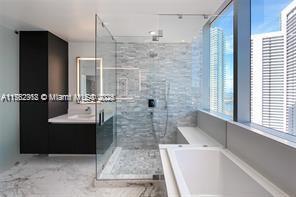 full bathroom with a bath, marble finish floor, a stall shower, and a wealth of natural light