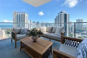 balcony with an outdoor living space and a view of city