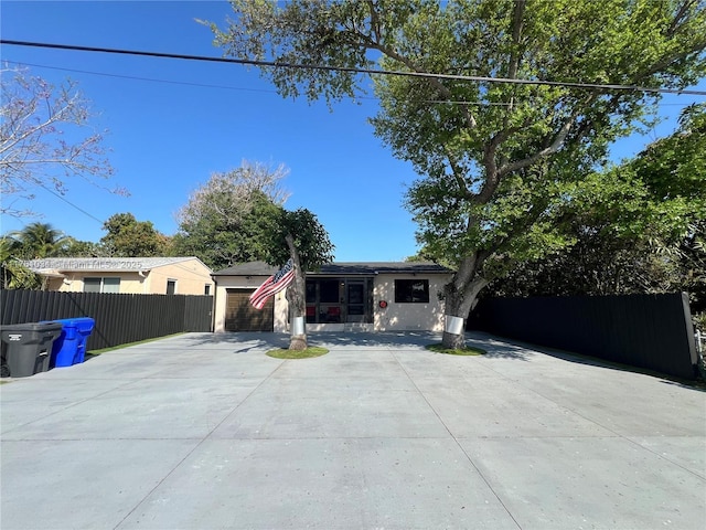 view of front of home featuring driveway, an attached garage, and fence