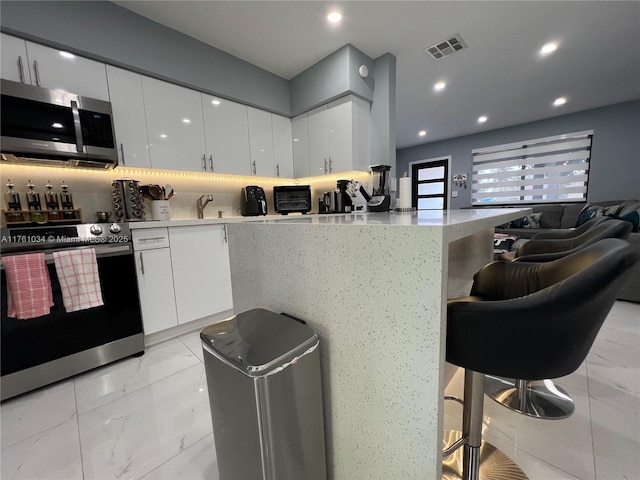 kitchen with stainless steel appliances, marble finish floor, visible vents, and white cabinets