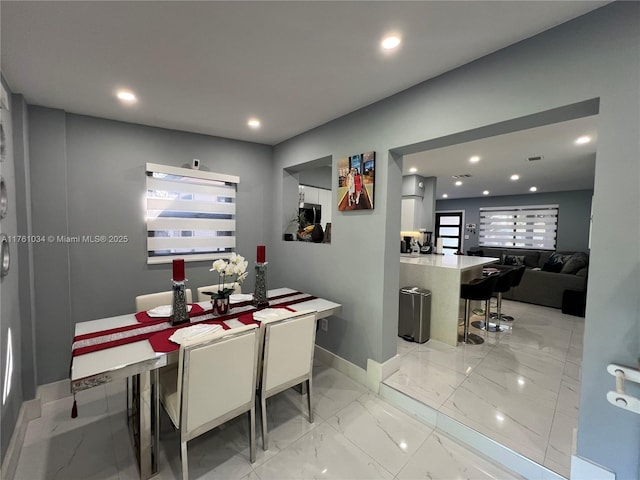 dining space featuring recessed lighting, marble finish floor, and baseboards