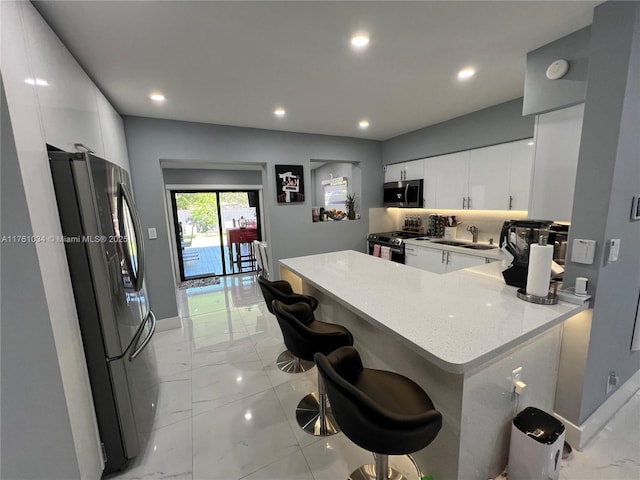 kitchen featuring white cabinetry, light countertops, marble finish floor, and appliances with stainless steel finishes