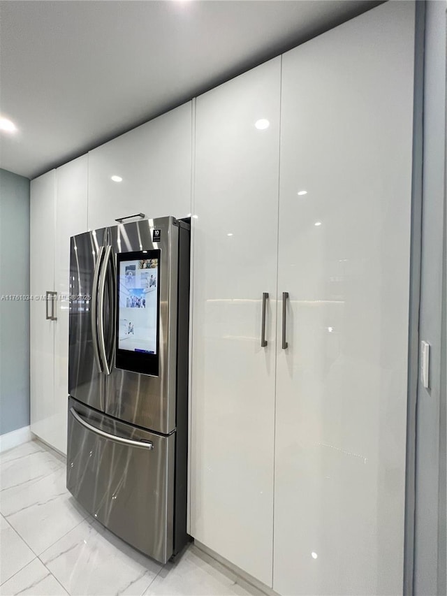 interior details featuring modern cabinets, white cabinets, and refrigerator with glass door