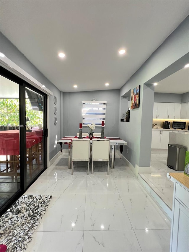 dining space featuring recessed lighting, baseboards, and marble finish floor