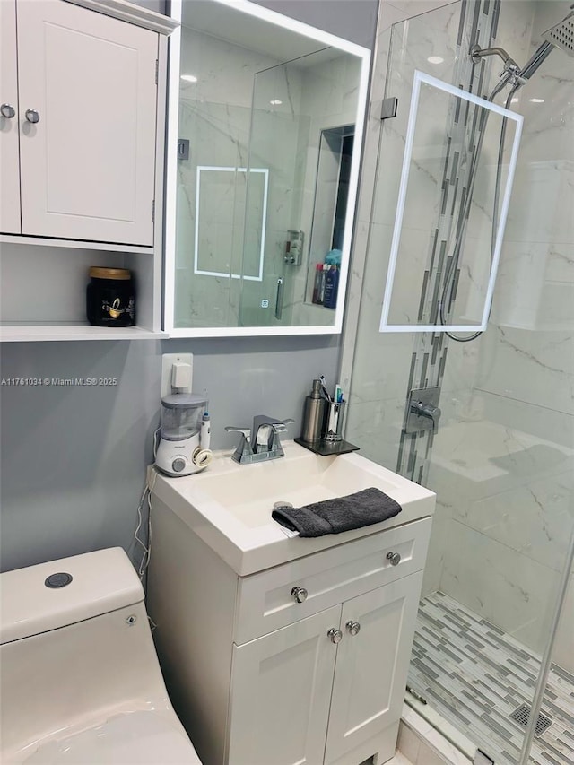 bathroom with a marble finish shower and vanity