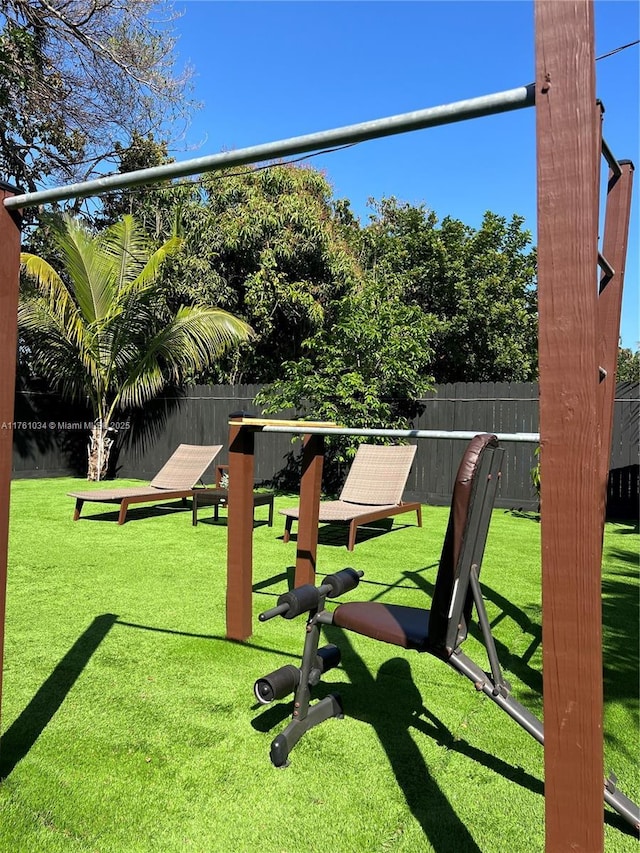 view of property's community with a yard and fence