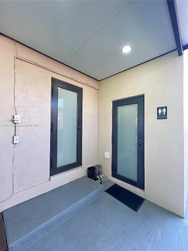 doorway to property featuring stucco siding