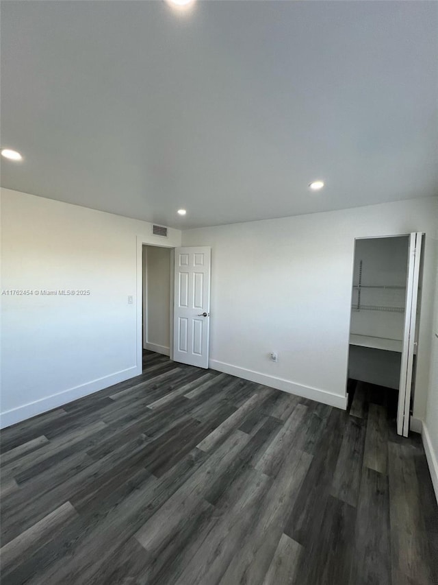 unfurnished bedroom featuring recessed lighting, baseboards, and dark wood-style flooring