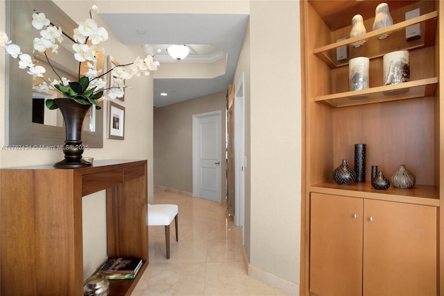 corridor with baseboards and crown molding