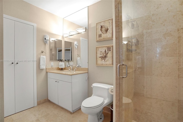 bathroom featuring vanity, toilet, and a stall shower