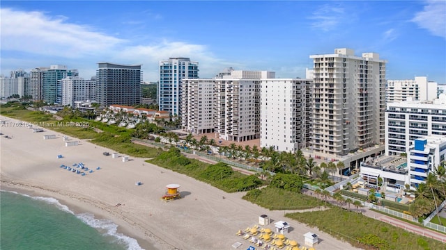 birds eye view of property with a beach view, a view of city, and a water view