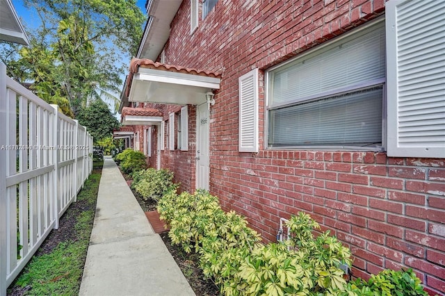 view of home's exterior featuring brick siding and fence