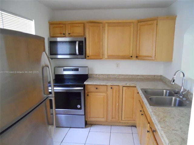 kitchen featuring a sink, appliances with stainless steel finishes, light tile patterned flooring, and light brown cabinets