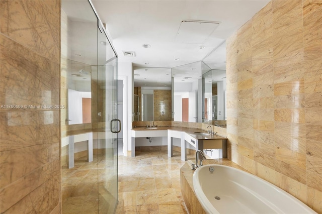 bathroom featuring visible vents, a garden tub, a stall shower, tile walls, and vanity