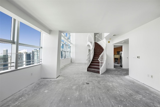 1395 Brickell Ave Unit 3403, Miami, FL 33131 - unfurnished living room with visible vents, a city view, and stairs