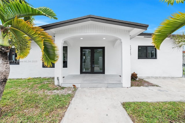 doorway to property featuring french doors and stucco siding