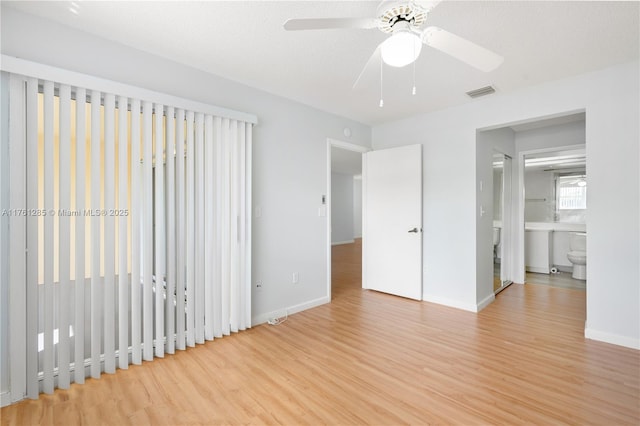 unfurnished bedroom featuring wood finished floors, visible vents, and baseboards