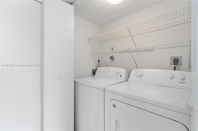 laundry area featuring laundry area, a textured ceiling, and separate washer and dryer