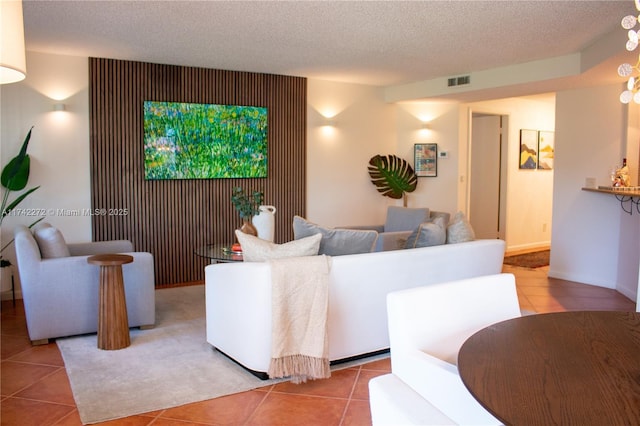 living room with tile patterned floors, visible vents, and a textured ceiling