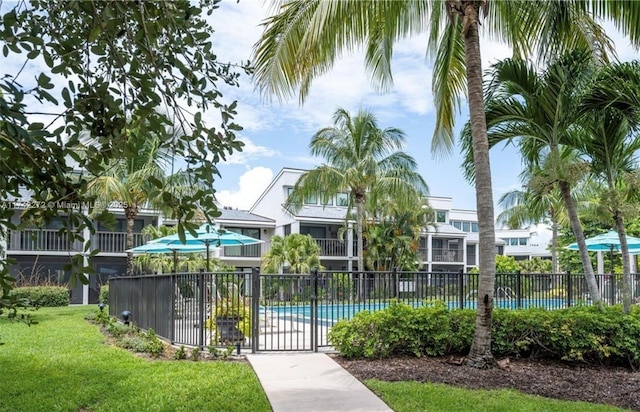 view of home's community featuring a pool, a lawn, and fence