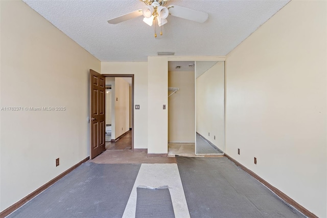 unfurnished bedroom featuring visible vents, a textured ceiling, baseboards, and a ceiling fan