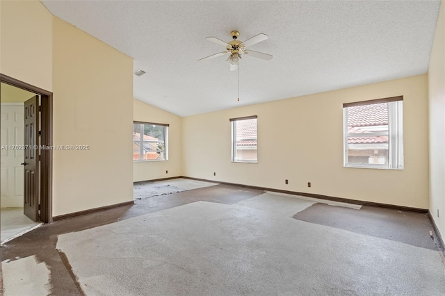 spare room with a ceiling fan, baseboards, vaulted ceiling, a textured ceiling, and carpet flooring