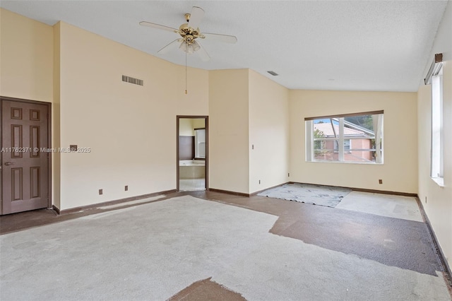 carpeted spare room featuring baseboards, visible vents, and high vaulted ceiling