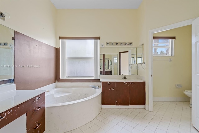 full bath featuring vanity, a garden tub, toilet, and tile patterned flooring