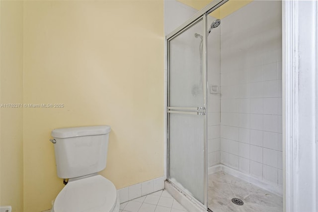 bathroom with tile patterned flooring, a stall shower, and toilet