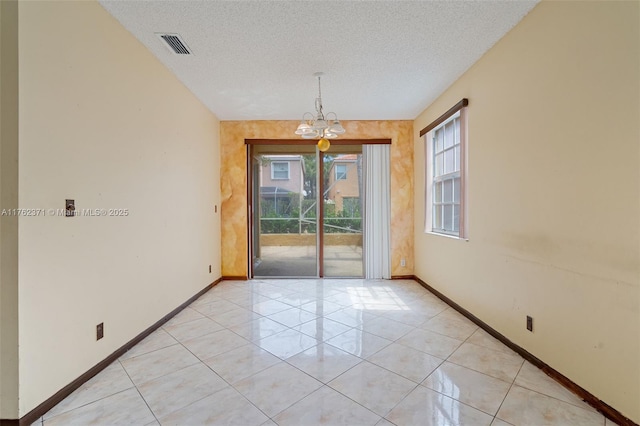 spare room featuring light tile patterned floors, baseboards, visible vents, an inviting chandelier, and a textured ceiling