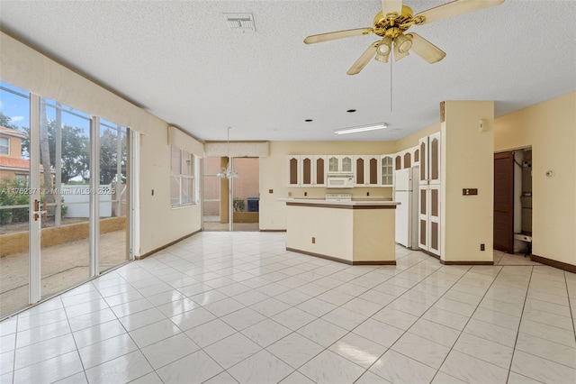 unfurnished living room featuring light tile patterned floors, visible vents, a textured ceiling, and a ceiling fan