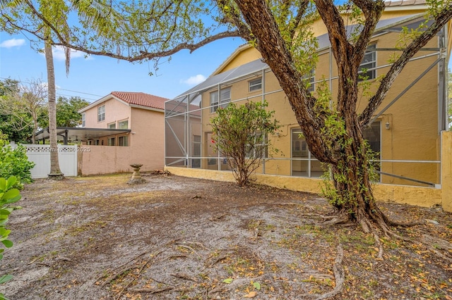 view of yard featuring glass enclosure and fence