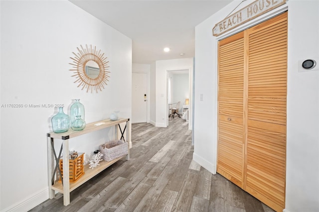 corridor featuring wood finished floors and baseboards