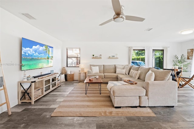 living room with a ceiling fan, wood finished floors, visible vents, and baseboards