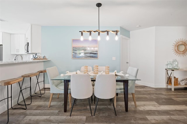 dining space featuring wood finished floors and baseboards