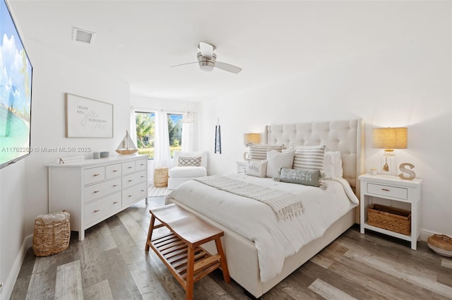 bedroom featuring visible vents, ceiling fan, baseboards, and wood finished floors