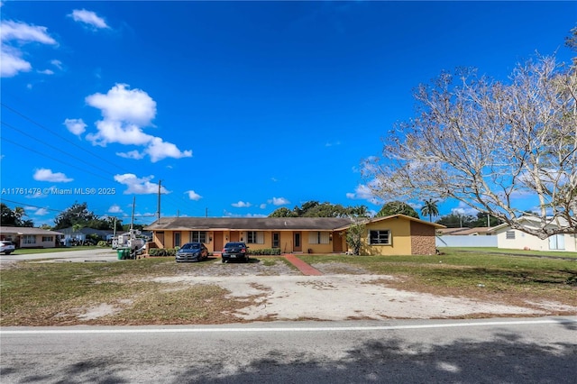 single story home with stucco siding and a front yard