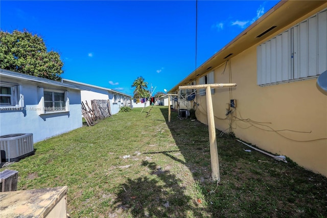 view of yard featuring fence and central AC