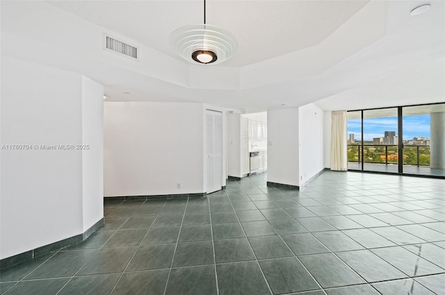 3600 Yacht Club Dr Unit 1102, Aventura, FL 33180 - empty room with visible vents, a raised ceiling, baseboards, and dark tile patterned flooring