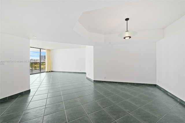 3600 Yacht Club Dr Unit 1102, Aventura, FL 33180 - empty room with dark tile patterned floors, a raised ceiling, and baseboards