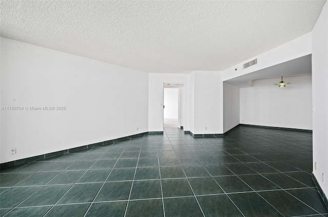 3600 Yacht Club Dr Unit 1102, Aventura, FL 33180 - empty room featuring visible vents, baseboards, a textured ceiling, and dark tile patterned floors