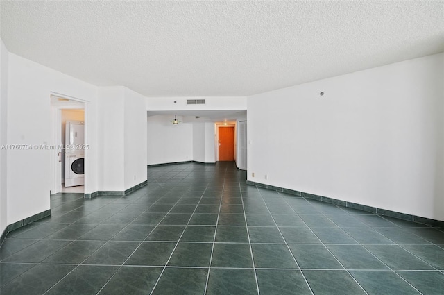 3600 Yacht Club Dr Unit 1102, Aventura, FL 33180 - spare room with baseboards, visible vents, a textured ceiling, stacked washer / dryer, and dark tile patterned floors