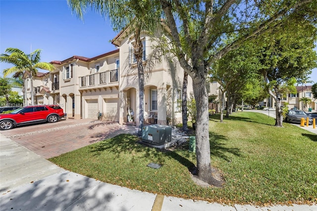 view of front of house featuring stucco siding, driveway, a residential view, a front yard, and an attached garage