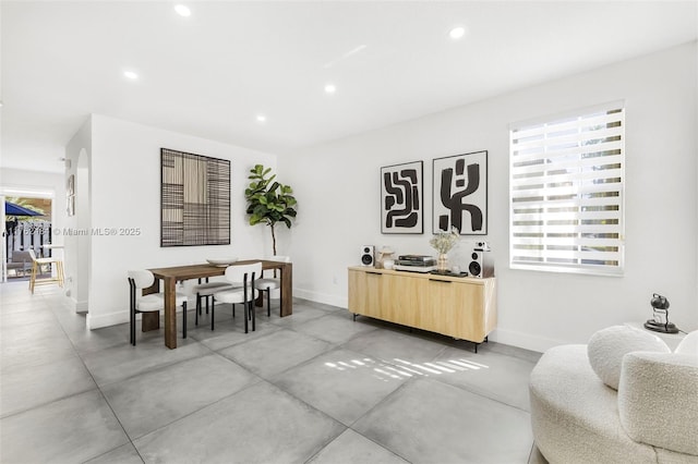 dining room with recessed lighting, baseboards, and concrete flooring