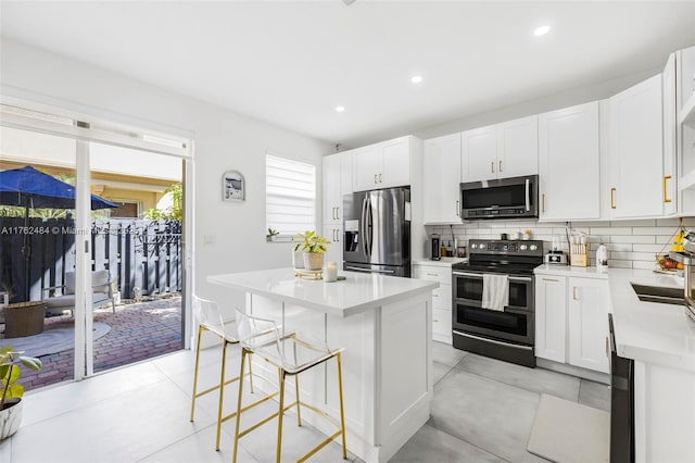 kitchen with a breakfast bar, a center island, tasteful backsplash, and stainless steel appliances