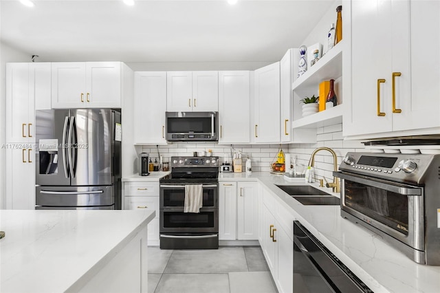 kitchen with backsplash, appliances with stainless steel finishes, open shelves, and a sink